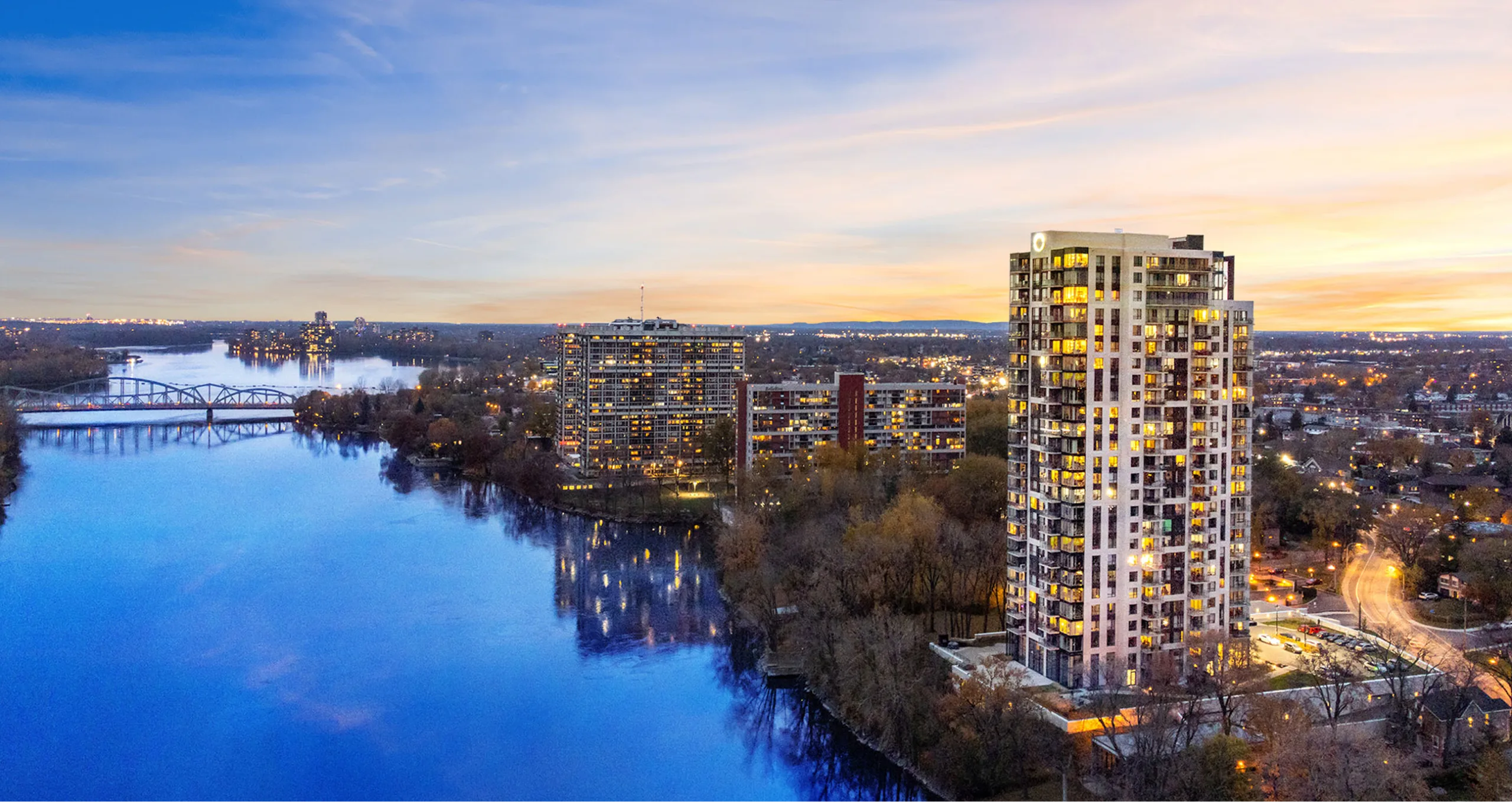 Édifice sur le bord de l'eau, au couché du soleil