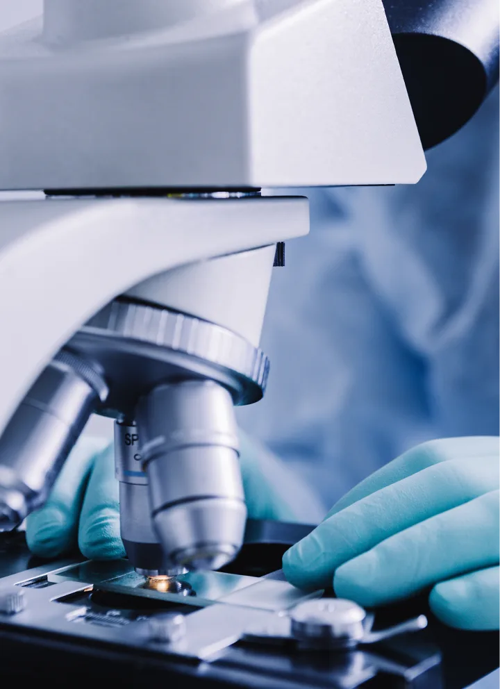 Microsope avec le gant d'un scientifique